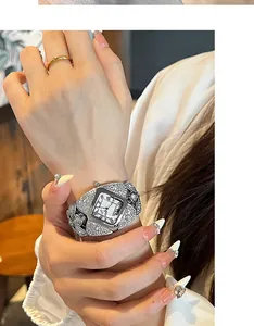 Gros plan d'une montre à quartz en strass argentés et d'une bague dorée sur un poignet