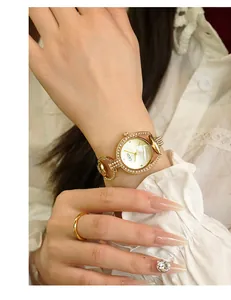 Close-up of golden GEDI bracelet watch for women with rhinestones and white dial on wrist