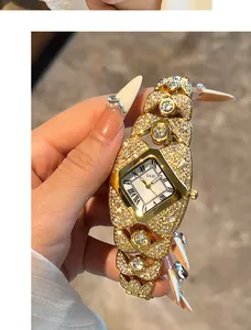 Détail d'une montre de luxe dorée ornée de diamants avec un cadran unique en forme de losange