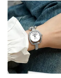 Close-up of GEDI silver watch with sparkling rhinestones worn by a model in denim