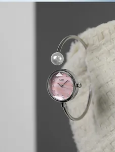 Dettaglio dell'orologio GEDI con quadrante in madreperla rosa e bracciale con perle