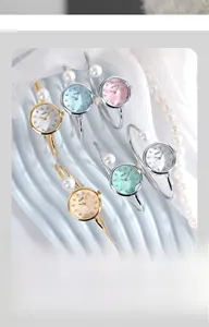 Dettaglio dell'orologio a bracciale con perle e quadrante in madreperla per donna