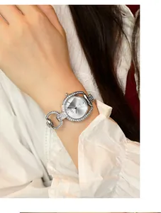 Close-up of GEDI silver rhinestone watch with hollow chain bracelet on a wrist