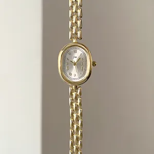 Detailed macro view of vintage golden oval watch dial with Roman numerals and metal chain