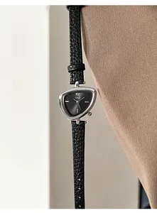 Detail view of triangular silver watch dial with black leather strap and minimalist design