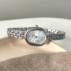 Detailed macro view of the oval silver watch dial featuring classic Roman numerals