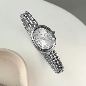 Detailed top view of a vintage silver oval watch with roman numerals and metal chain band