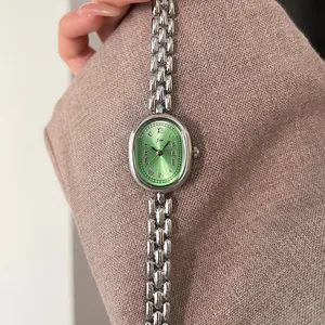 Detail shot of vintage oval watch with green sunray dial and silver alloy bracelet