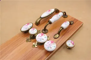 Detailed macro view of vintage ceramic drawer knobs with floral patterns and bronze base
