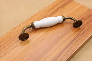 Detail view of European vintage ceramic cabinet handle with antique bronze metal base