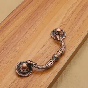 Detailed macro of vintage red bronze drawer pull with intricate floral relief carvings