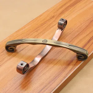 Detail view of antique zinc alloy handles in bronze and red copper finishes on wood