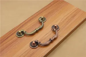 Detailed view of antique bronze cabinet ring handles with classic European floral carving