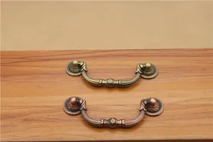 Detail showing antique bronze and red copper finishes on classical cabinet drawer pulls