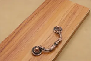 Detailed view of antique bronze cabinet drawer pull handle with embossed floral base