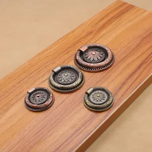 Macro detail of antique bronze round knobs with floral relief on wood panel