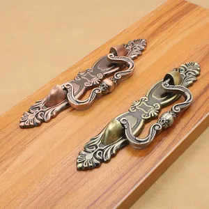 Close-up of European vintage drawer handles in antique bronze with floral carvings