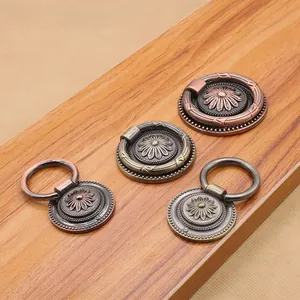 Detail of antique zinc alloy drawer pulls in bronze and copper finishes with floral relief