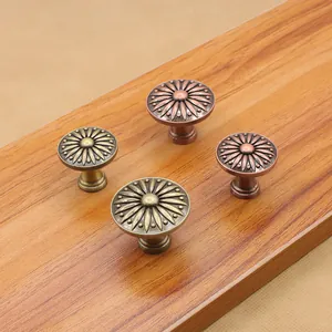 Dettaglio di pomelli vintage in lega di zinco con intagli di girasole in bronzo