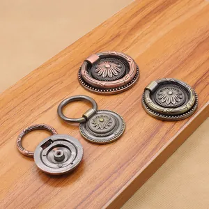 Macro detail of antique bronze zinc alloy drawer pulls with floral engraving on wood