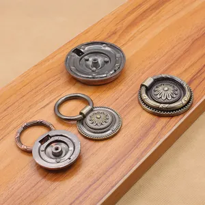 Close-up of vintage bronze cabinet handles with embossed floral patterns and pull rings