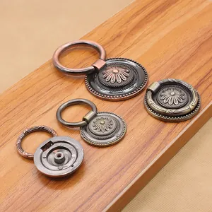 Antique zinc alloy drawer pulls with floral relief and bronze finish on wooden background