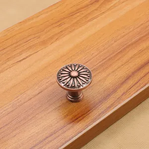 Dettaglio del pomello rotondo in bronzo antico con rilievo floreale su legno