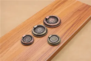 Detail of vintage zinc alloy ring handles with floral relief for cabinets and drawers