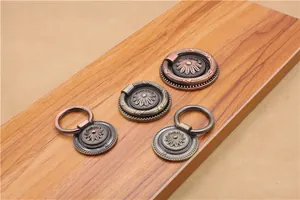 Detailed macro of antique zinc alloy furniture pulls with embossed daisy flower patterns