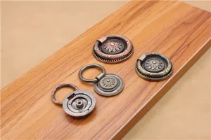 Detail view of antique bronze round ring drawer handles with floral texture in two sizes