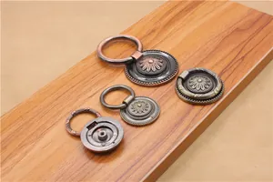 Detail of antique zinc alloy drawer pulls with vintage floral carvings and bronze finish