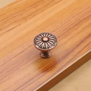 Dettaglio del pomello in bronzo rosso con rilievo a girasole su base legno