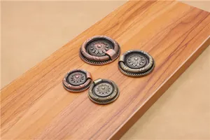 Detailed macro view of antique bronze round ring handles with embossed floral patterns