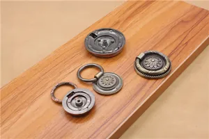 Detail of antique zinc alloy furniture ring pulls with vintage floral base on wood