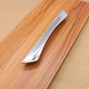 Macro detail of polished chrome silver drawer handle on wood display board