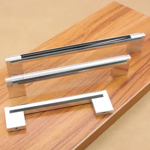 Modern black aluminum cabinet handles in three sizes on a natural wood background