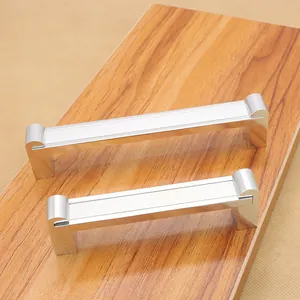 Moderne silberne Möbelgriffe aus Aluminium in zwei Größen auf einer Holzoberfläche
