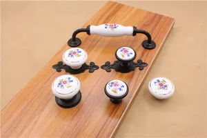 Detail of floral ceramic cabinet knobs and drawer pulls with black metal base