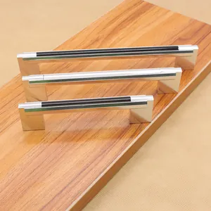 Three sizes of modern black and silver U-shaped aluminum cabinet handles on wood