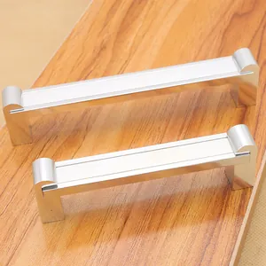 Nahaufnahme silberner Möbelgriffe aus Aluminium in verschiedenen Größen auf Holz