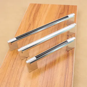 Three sizes of modern chrome cabinet handles with black striped inlay on wood