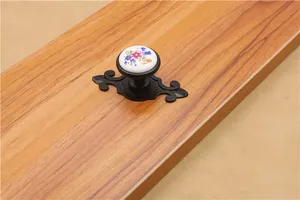 Detail of vintage ceramic drawer knob with floral pattern and black ornate base