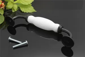 Detail showing white ceramic handle with black metal base and mounting screws