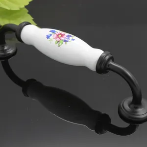 Detail of vintage ceramic drawer handle with floral pattern and black metal base