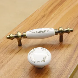 Detail of European retro ceramic cabinet handles with gold floral patterns and bronze base