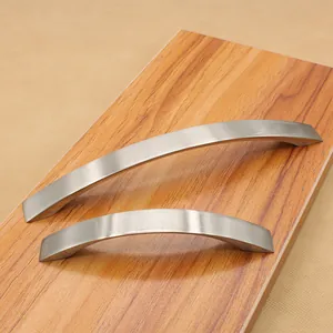 Macro detail of brushed aluminum curved furniture handles on a wooden surface