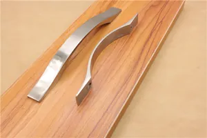 Dettaglio di maniglie curve in alluminio per mobili con finitura in metallo spazzolato