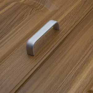 Matte silver aluminum U-shaped furniture handle installed on a brown wood cabinet door