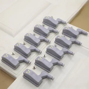 Macro detail of ten grey LED cabinet hinge lights with mounting screws on a white surface