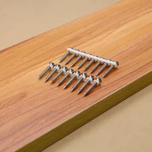 Close-up of collated stainless steel self-tapping screws on a wooden surface